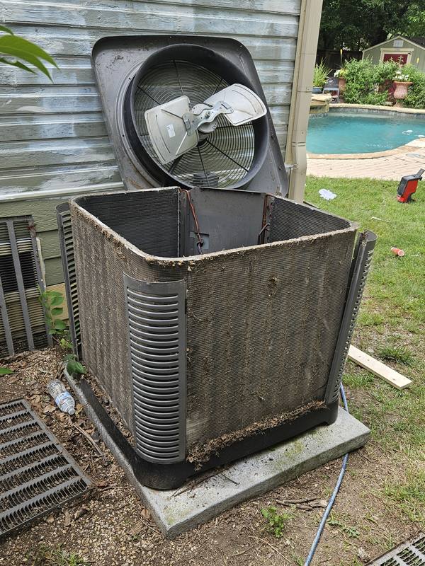Before: outdoor AC condenser with the fan top lifted off and the coil matted with dirt