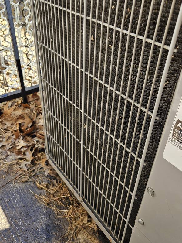 After: the same condenser coil cleaned, with clear, wet fins