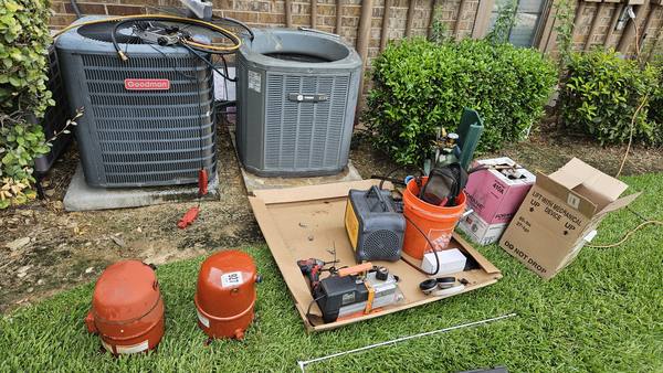 Compressor replacement in progress: old compressors removed beside the outdoor units, with recovery and vacuum equipment