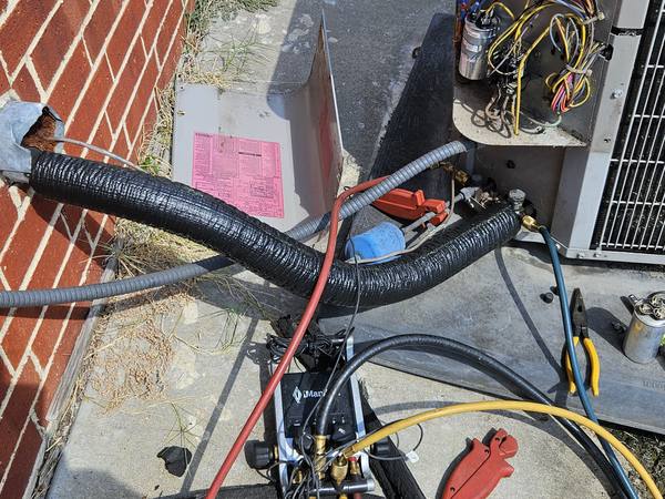 After: new insulation on the suction line, with gauge hoses connected to check the system