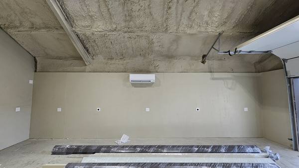 Shop building interior with a spray-foam ceiling and a new wall-mounted ductless mini-split indoor head