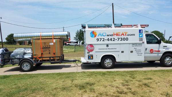 AC and Heat service truck towing a trailer loaded with new HVAC equipment